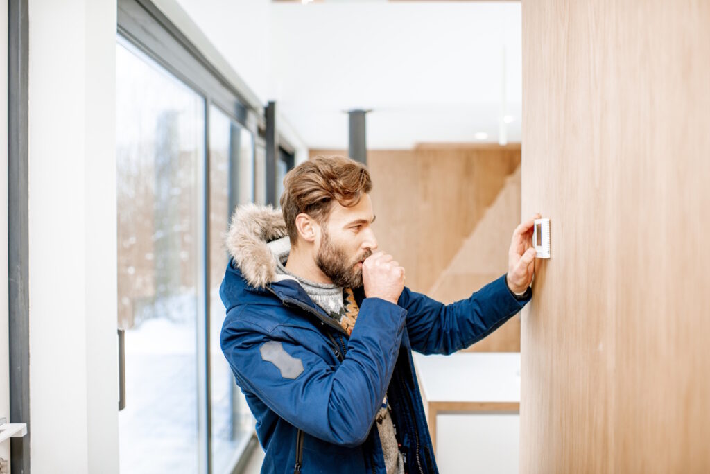man checking home thermostat